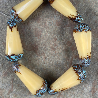 Strand of 9x20mm beige faceted Czech glass beads.