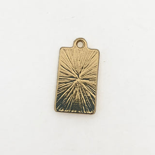 Back side of a gold plated rectangular charm with a starburst lined engraved pattern.