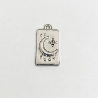 Front side of a silver plated rectangular charm with a crescent moon and clear crystal.