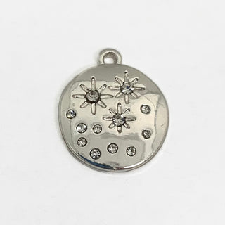 Front side of a silver plated charm with 12 clear crystals and star engravings.