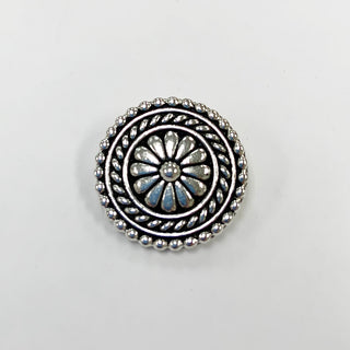 Small round silver tone flower textured button with embellished edges.