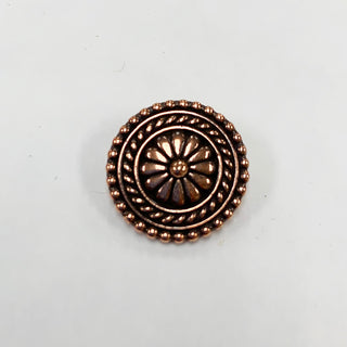 Small round copper tone flower textured button with embellished edges.