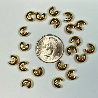 Dime for scale surrounded by gold plated bead crimps.