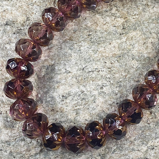 Strand of faceted 7x10mm purple and bronze Czech glass cruller beads.