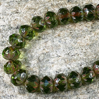 Strand of peridot 6x9mm Czech glass cruller beads.