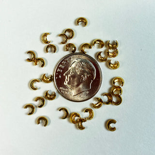 Dime for scale surrounded by gold plated bead crimps.
