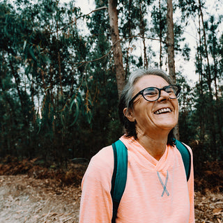 Stock image of old woman hiker in woods.
