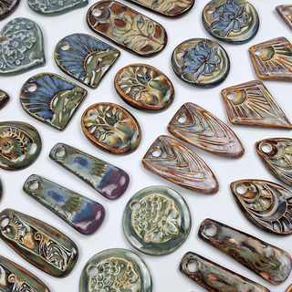 several ceramic pendants on a white background