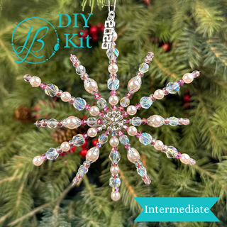 pink beaded snowflake ornament in front of christmas tree