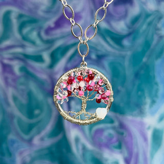 pink beaded snowflake ornament in front of christmas tree