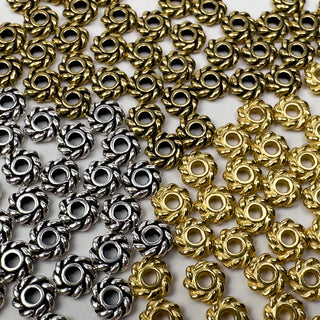TierraCast Twist Spacer Beads in Gold and Silver laying flat on a white table