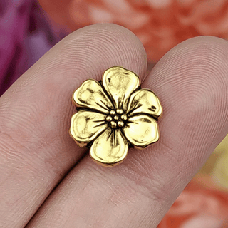 Antique gold plated metal button shaped like an apple blossom