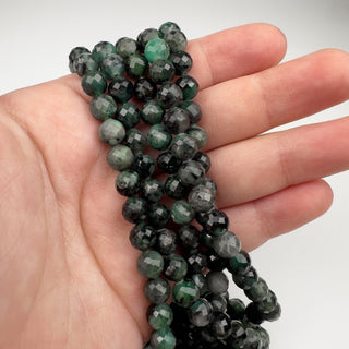 Emerald 7mm Round Faceted 15.5in Strand in hand
