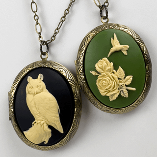 Two vintage-style cameo locket pendants with owl and hummingbird designs on a white background