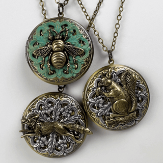 Three decorative locket necklaces with animal-themed pendants on a white background