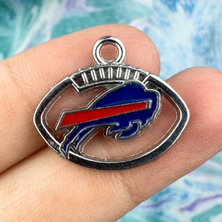 Buffalo Bills Style Football Charm on a person's fingers on a blue background