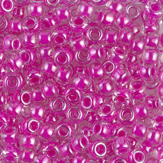 Closeup of size 6/0 fuschia lined crystal Miyuki seed beads.