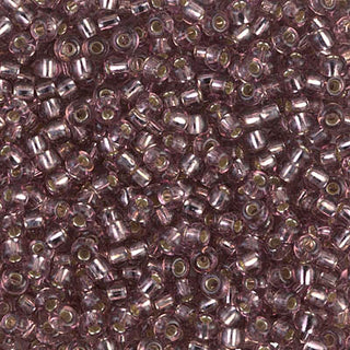 Closeup of size 8/0 silver lined smoky amethyst Miyuki seed beads.