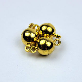 3 gold magnets on white background

