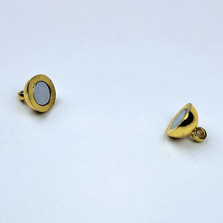 2 halves of a gold magnet on white background