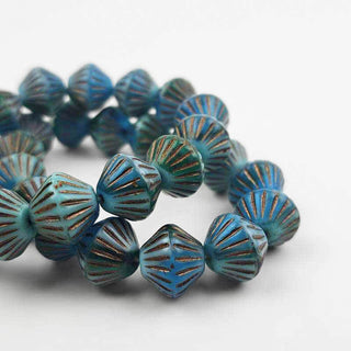 Blue tone bicone shaped czech glass beads on a white background