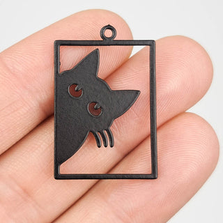 black stainless steel charm that looks like a cat peering out of a window frame