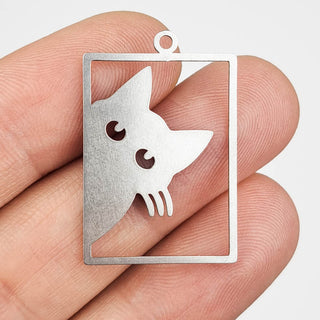 stainless steel charm that looks like a cat peering out of a window frame