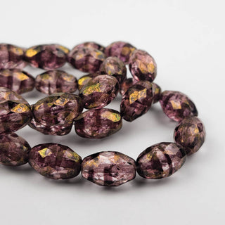 purple tone faceted oval beads with a gentle bronze finish on a white background