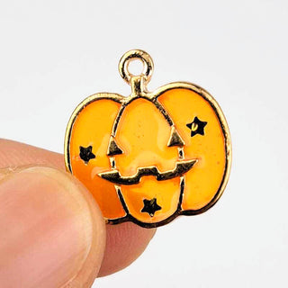 Jack O Lantern Charm Enamel Orange Transparent with Gold in a person's fingers