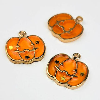 three Jack O Lantern Charms Enamel Orange Transparent with Gold on a white background