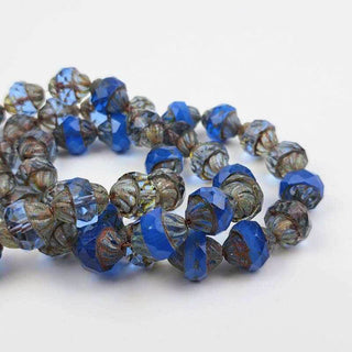 Blue Czech Glass Beads laying in a pile on a white background