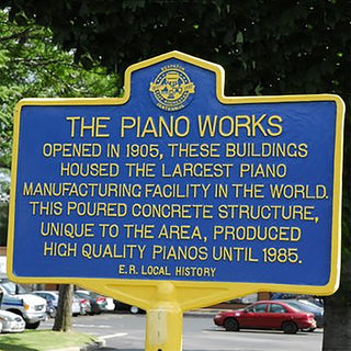 Piano Works historic marker in parking lot.