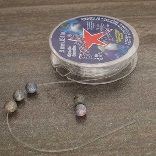 Stretch Magic Cord with beads on a textured surface