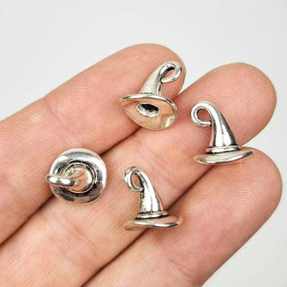 four 3D silver tone witch hat or wizard hat charms on a person's fingers