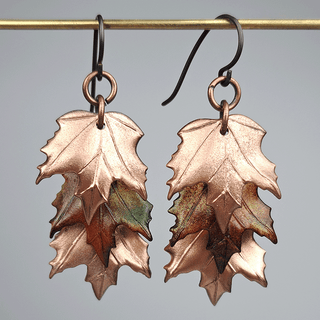 maple leaf copper tone leaf charms on copper earwires hanging on a gold bar
