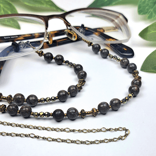 Glasses and brown Beaded Glasses Chain with green leaves in background