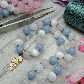 Knotted Gemstone Necklace with pastel charm and spool of thread and tweezers