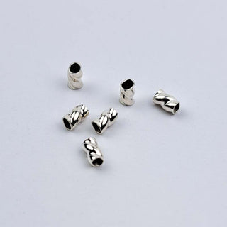 Closeup of sterling silver tornado crimps size .019 on a white background