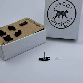 close up of three pairs of black cat stud earrings on a white background